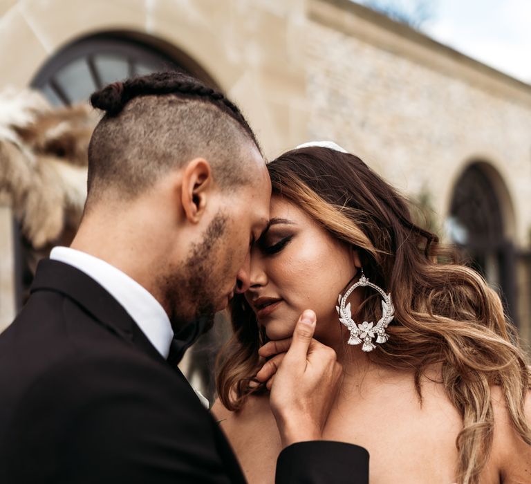 Bride with long wavy hair wearing stylish hoop earrings 