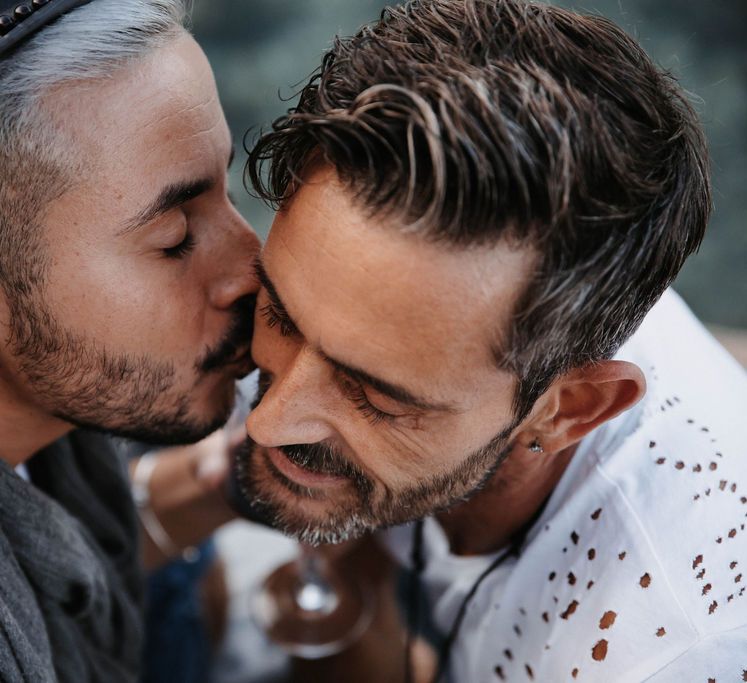 Groom kisses the cheek of his boyfriend during engagement session