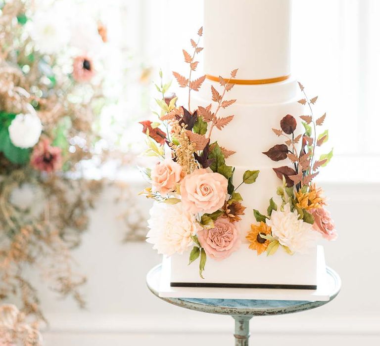 Autumn flower decoration on classic white wedding cake 