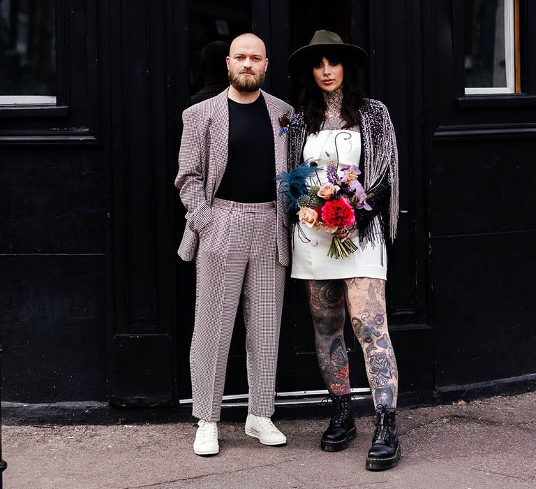 Alternative wedding inspiration in Shoreditch with groom in a check suit and trainers and bride in a short wedding dress and boots