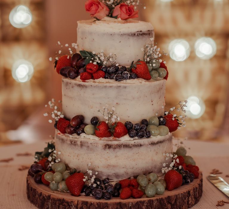 Wedding cake with naked frosting and fruit decoration 