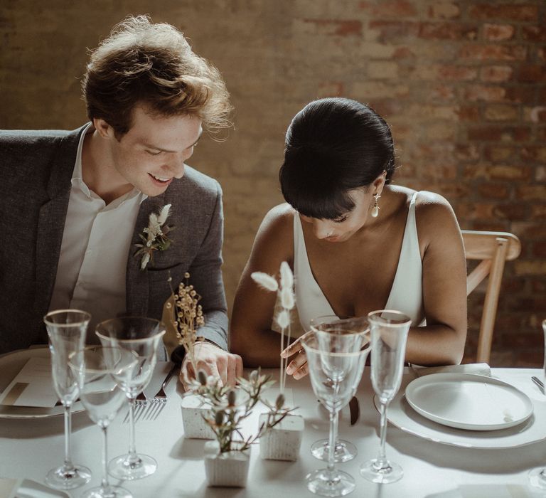 A bride and groom read the wedding menu.