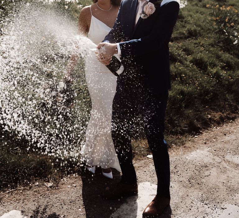 Bride and groom spraying champagne