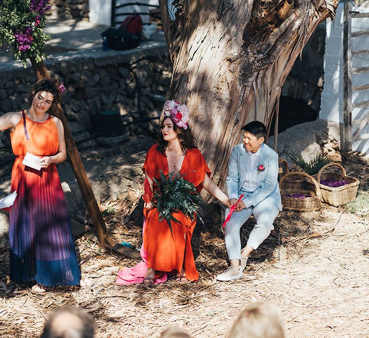 Brides sit down during wedding ceremony outdoors in Menorca