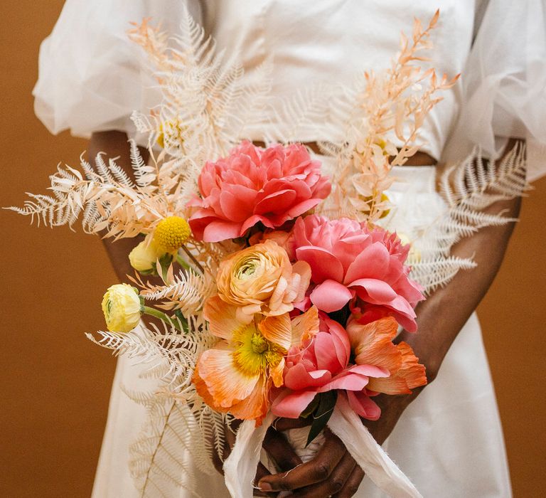 Pink, orange and yellow floral bouquet of poppies, dahlias and craspedia