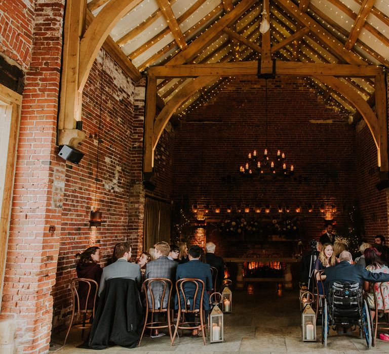 Interior of Hazel Gap Barn wedding venue with green and red flowers for autumn wedding ceremony