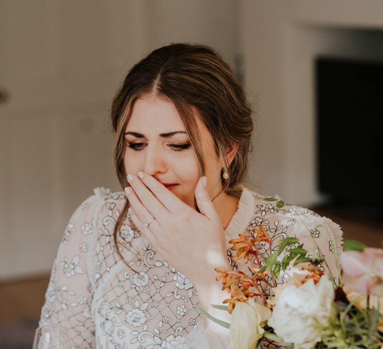 Bride becomes emotional on her wedding day as she lifts her hand to her mouth whilst holding back tears