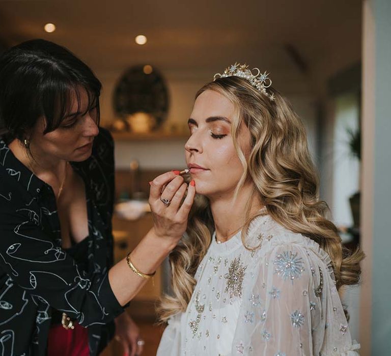 Bride has her makeup done on the morning of her wedding day in Cornwall on Solstice weekend