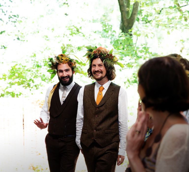 Grooms smile and stand by one another on their wedding day 