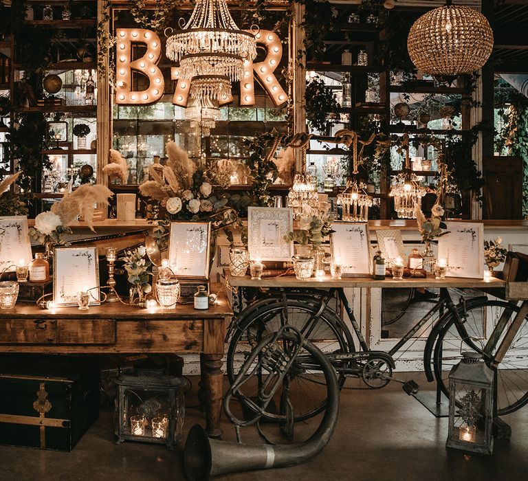 Bar with LED lighting in front of rustic table complete with silver frames