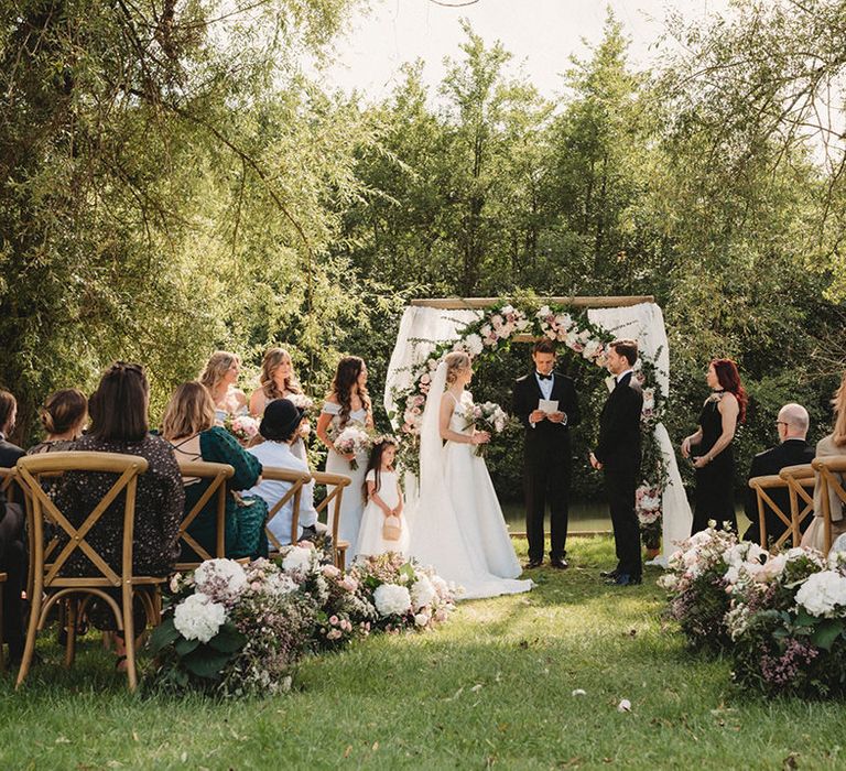 Outdoor wedding ceremony at Chateau Lagorce with white and pink wedding flowers