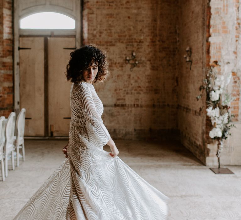 Boho bride with naturally curly hair swirling her patterned wedding dress in Bylaugh Hall 