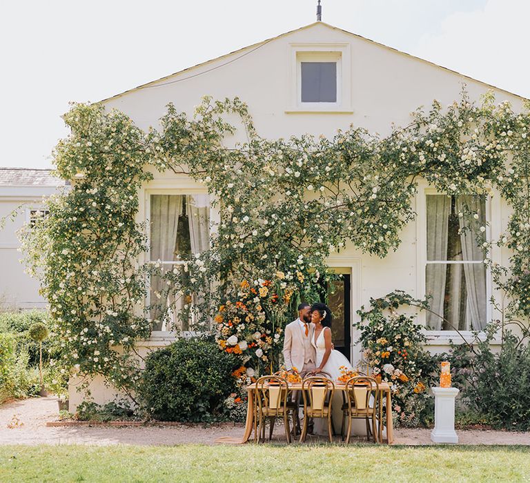 Outdoor wedding reception at Manor Hall, London with orange flowers and decor 