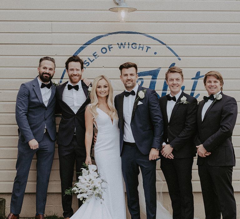 Bride with new husband and groomsmen in matching suits