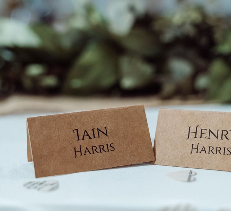 Cardboard style name place cards with the grooms' new names 