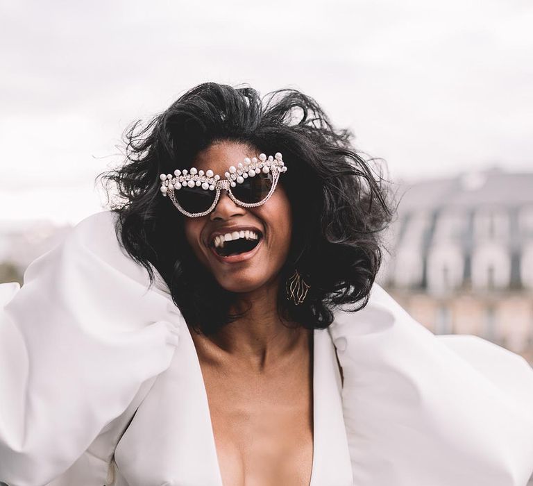 elopement in Paris with bride in a plunging v neck wedding dress and pearl sunglasses 