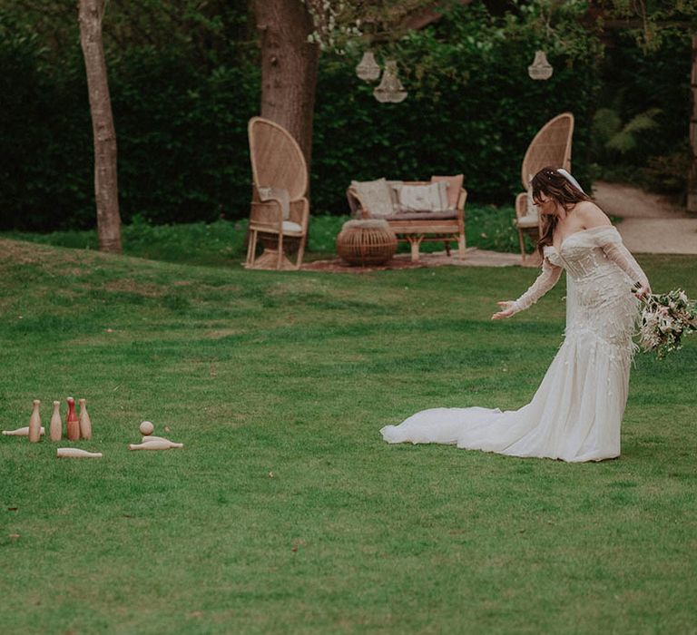 Bride and groom play a game of bowling on the lawn for their outdoor spring wedding at Millbridge Court