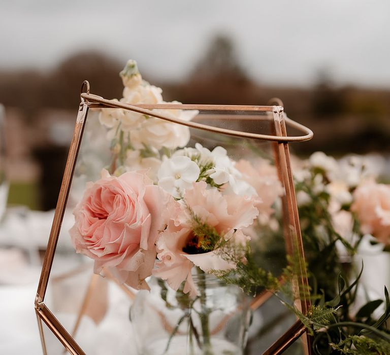 gold glass lantern filled with pink flower stems wedding table decor 