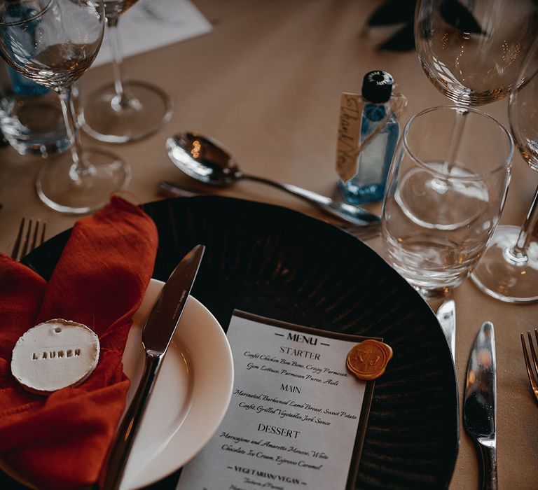 Black dinner plates complete with orange silk napkins for Autumnal styled tablescape 