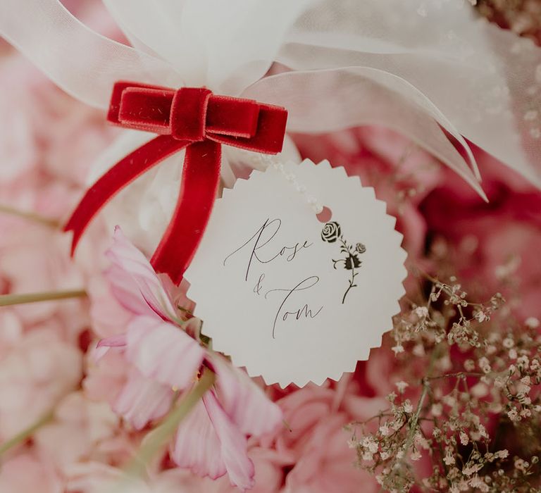 Noghl wedding favours in white fabric tied with pink velvet ribbon 