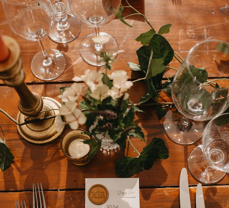 Green fabric napkin complete with white stationery and gold stamp on rustic wooden table