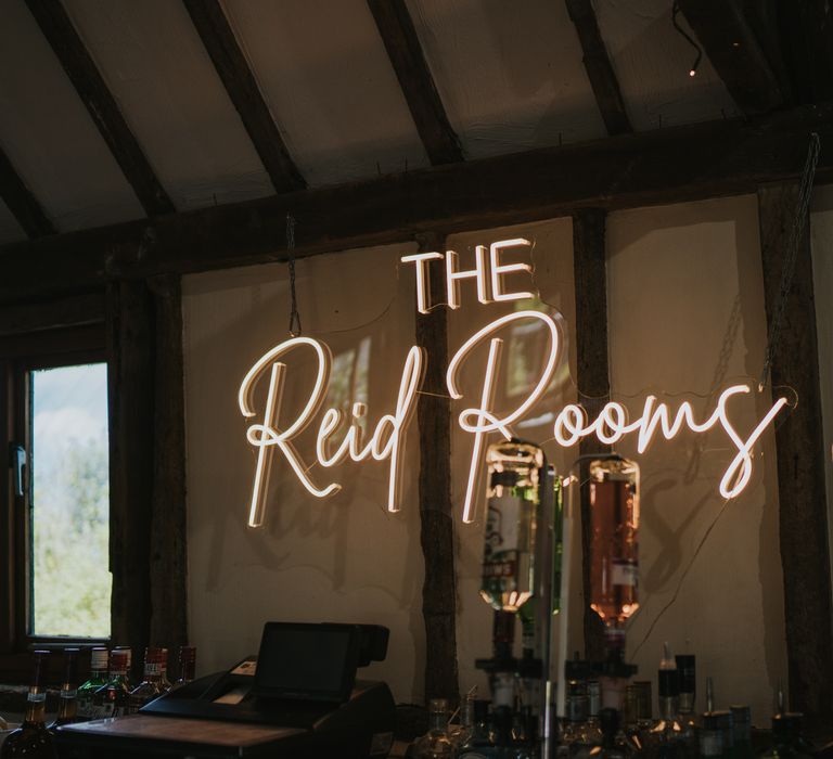 Large warm-toned neon sign for wedding saying The Reid Rooms 