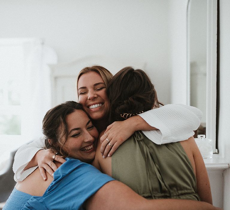 Bride hugs her bridal party on the morning of her wedding day