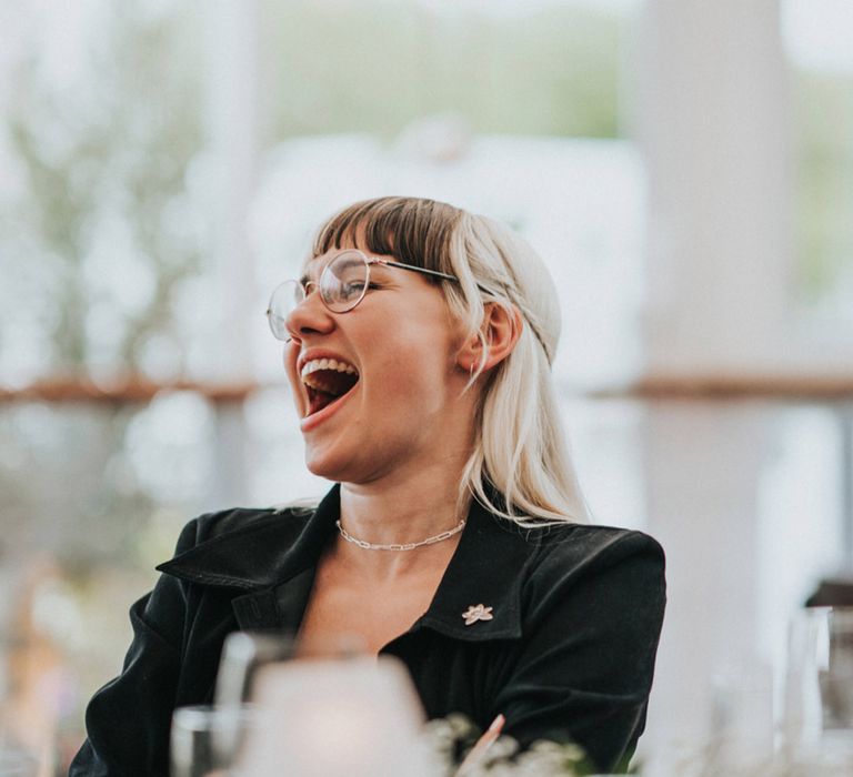 Bridesmaid laughs during wedding speeches 