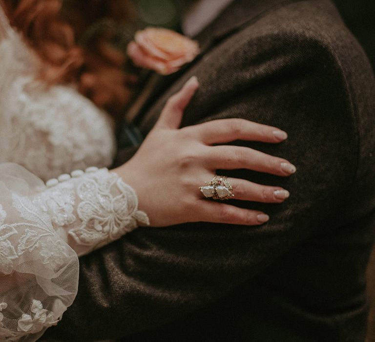 Bride's crystal and silver ring worn by boho bride with white patterned wedding nail art 