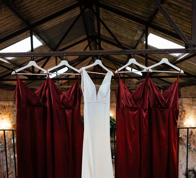 The bride's Savin London wedding dress hanging up with the bridesmaid dresses for the autumn wedding 