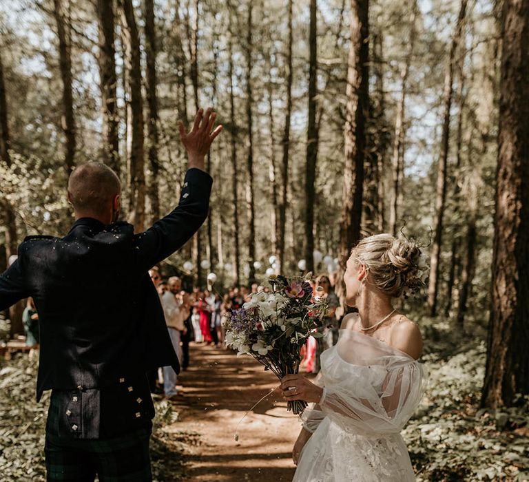 Bride and groom celebrate as they walk back down the aisle together as a married couple