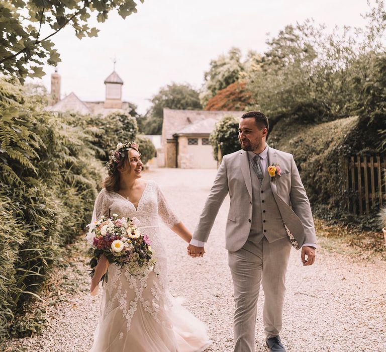 Cute couple portrait of the bride and groom walking hand in hand around their wedding venue in Lancashire 