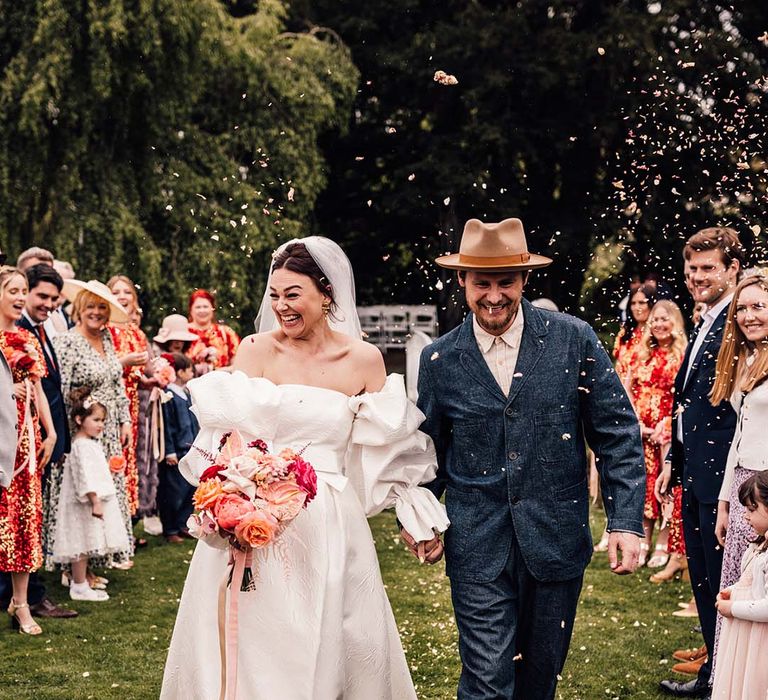 The bride and groom exit their wedding ceremony to confetti 