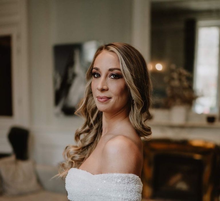 Bride in off shoulder sparkly mermaid wedding dress and neutral glam wedding makeup 