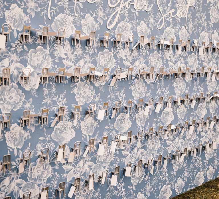 Blue and white floral wedding table plan signage with mini chairs with the guest's names on 