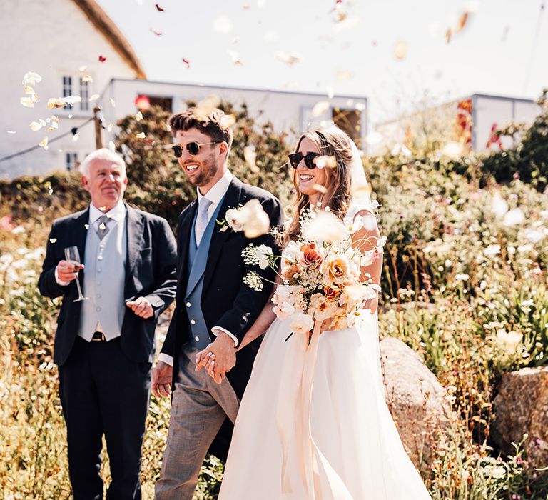 confetti moment with bride in a princess wedding dress and groom a morning suit at marquee Sennen Cove wedding 