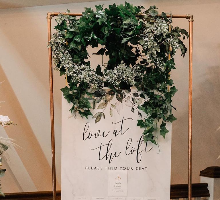 Black and white minimalist fabric wedding table plan with foliage and floral decorations 