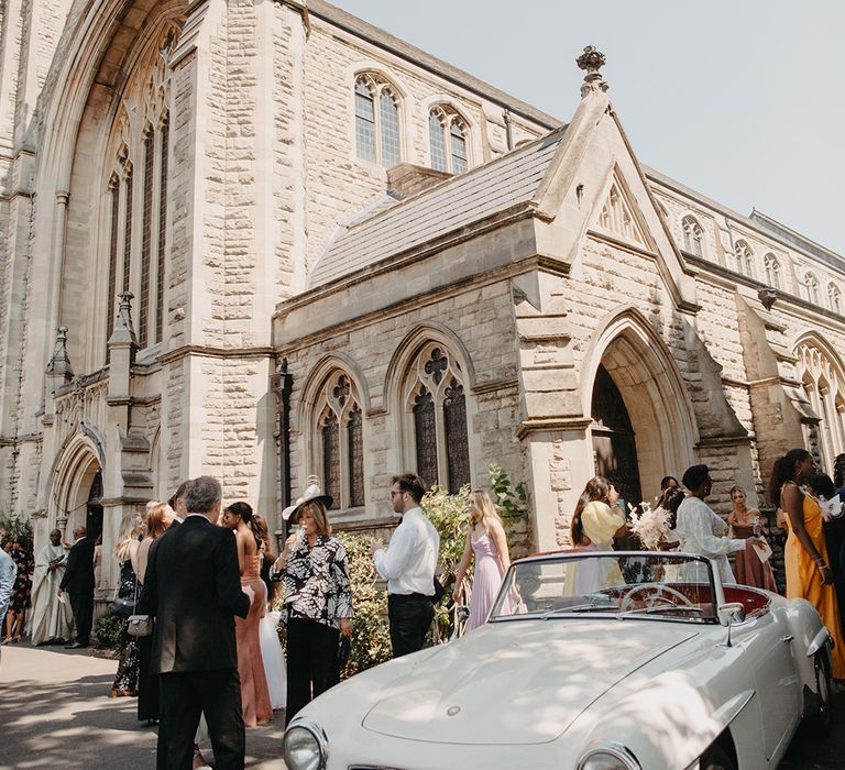 Vintage white Mercedes wedding car taking the bride and groom to the wedding reception 