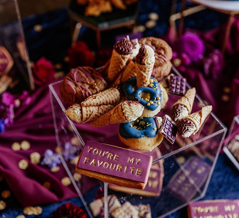 Wedding dessert table with mini ice cream cones and biscuits for guests 