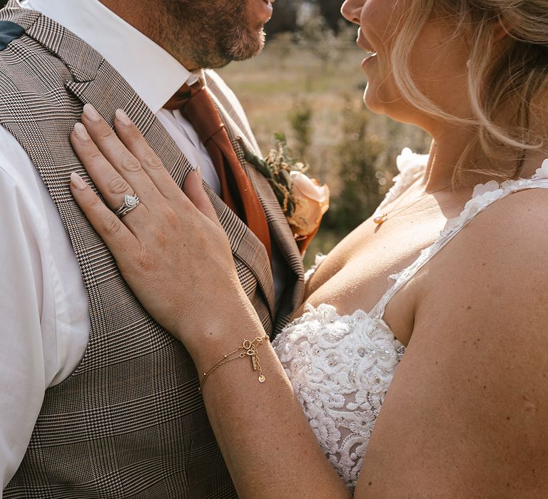 Bride with neutral wedding nails with diamond pear shaped engagement ring and wedding band 