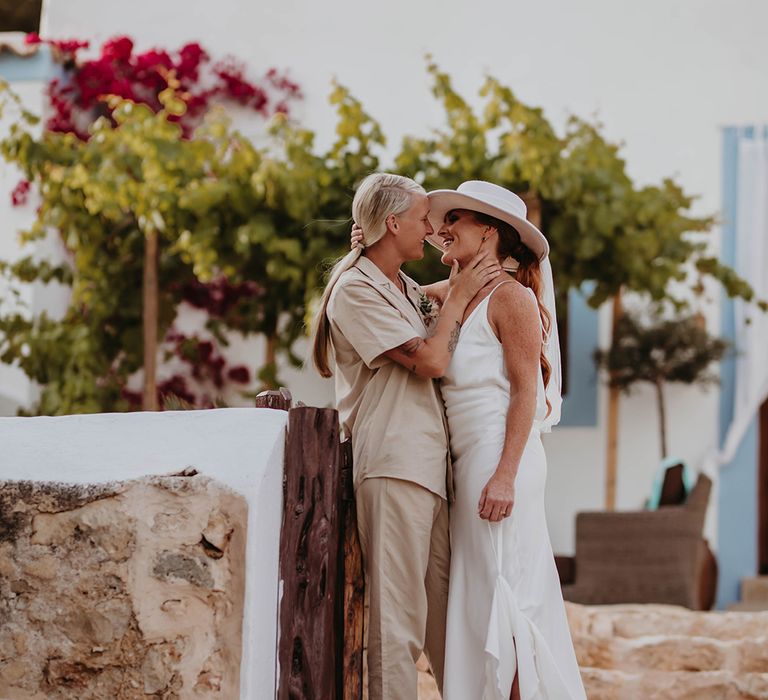 Two brides at Ibiza wedding in Can Frare Villa in Ibiza with one wearing a white bridal hat 