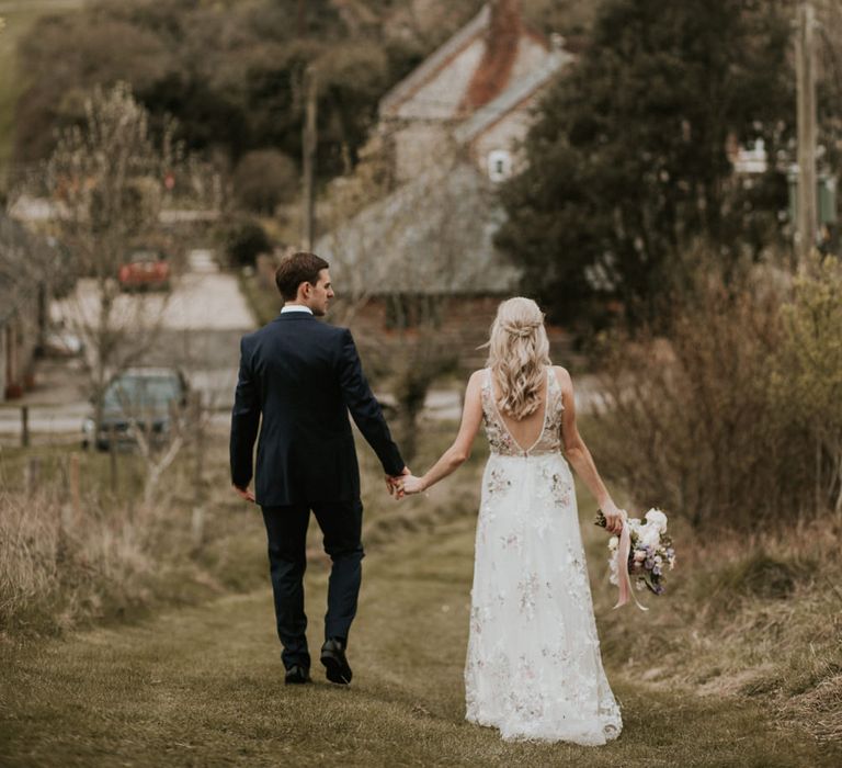 Bride in floral embroidered wedding dress and groom in navy suit at Upwaltham Barn wedding 