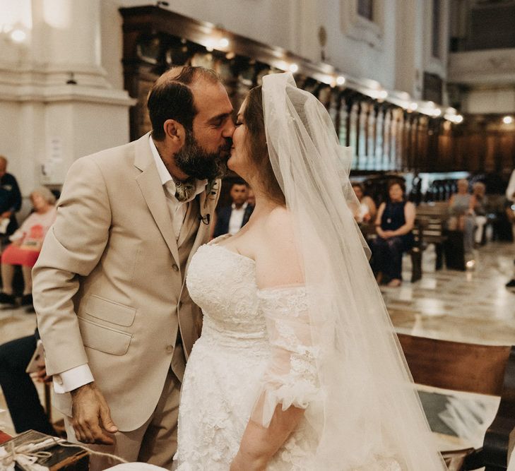 Bride and groom kiss at their Tuscany church wedding