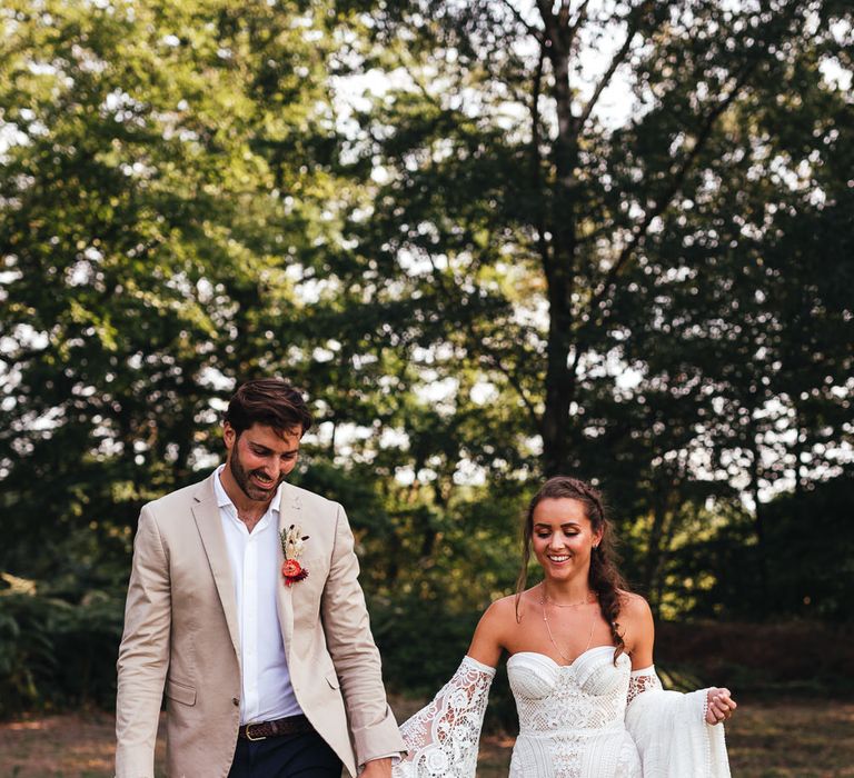 Bride & groom walk together in boho wedding inspiration 