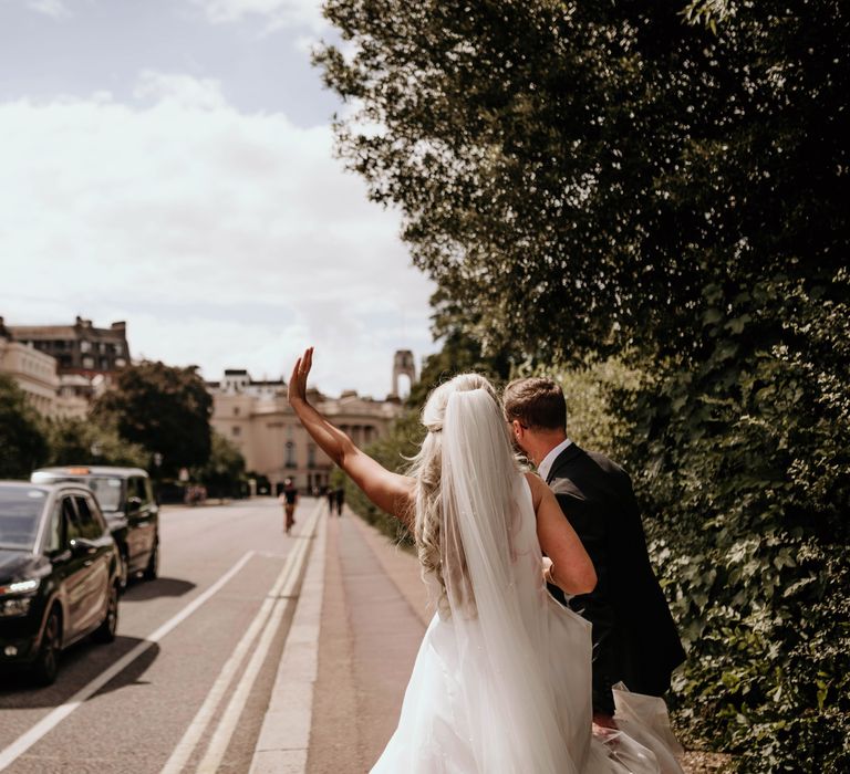 Bride & groom hail taxi in London