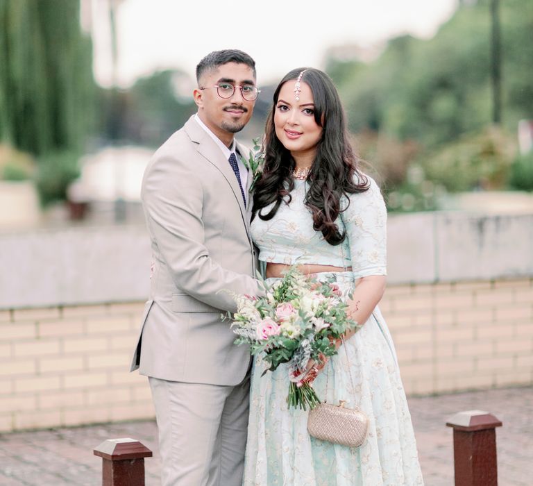 Sikh interfaith wedding with a bride in a mint green sari and groom in a beige suit 