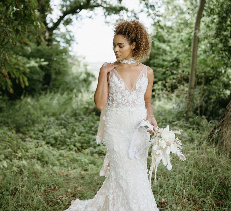 Boho bride in the woods at Berwick Lodge wearing floral lace embroidered wedding dress with plunge neckline and lace edged bridal cape