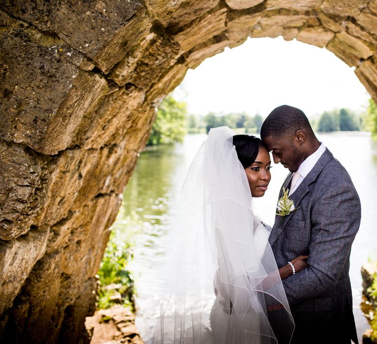 Bride & groom stand beneath archway on their wedding day