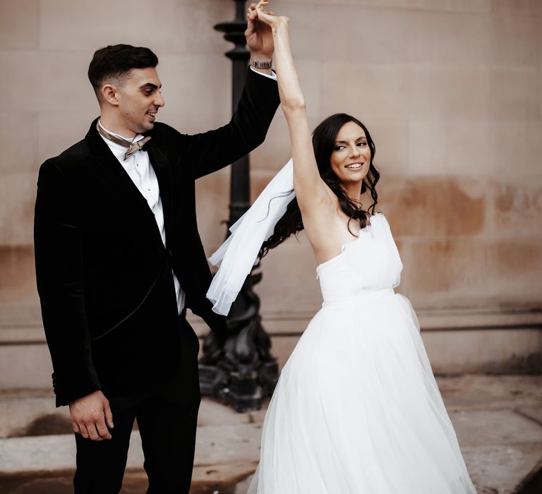 Groom spins bride around after wedding ceremony as she wears ASOS wedding gown at St George's Hall in Liverpool