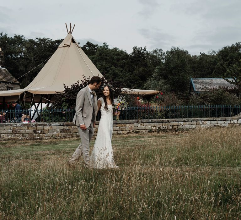 Bride & groom stand within the countryside on their wedding day